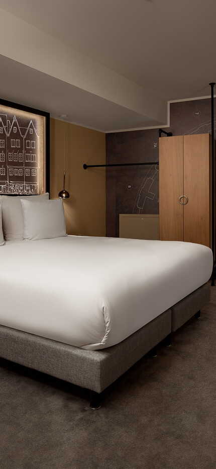 Ein stilvolles Schlafzimmer im Wasserturm mit modernem Bett und kunstvoller Wandgestaltung lädt zum Entspannen ein.