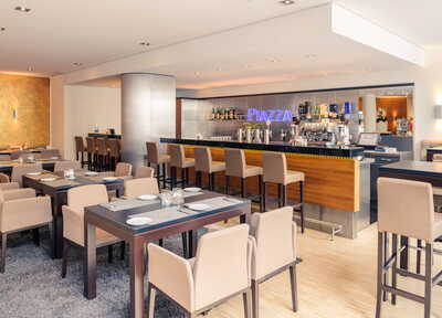 Ein stilvolles Restaurant mit modernen Sitzplätzen und einer gut bestückten Bar lädt zum Verweilen ein.