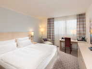 Ein elegantes Superior-Zimmer mit einem großen Bett, Schreibtisch und moderner Ausstattung bietet eine einladende Atmosphäre.