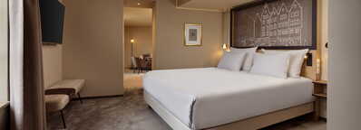 Ein elegantes Schlafzimmer im Wasserturm Köln mit einem großen Bett und einem stilvollen Wandbild.