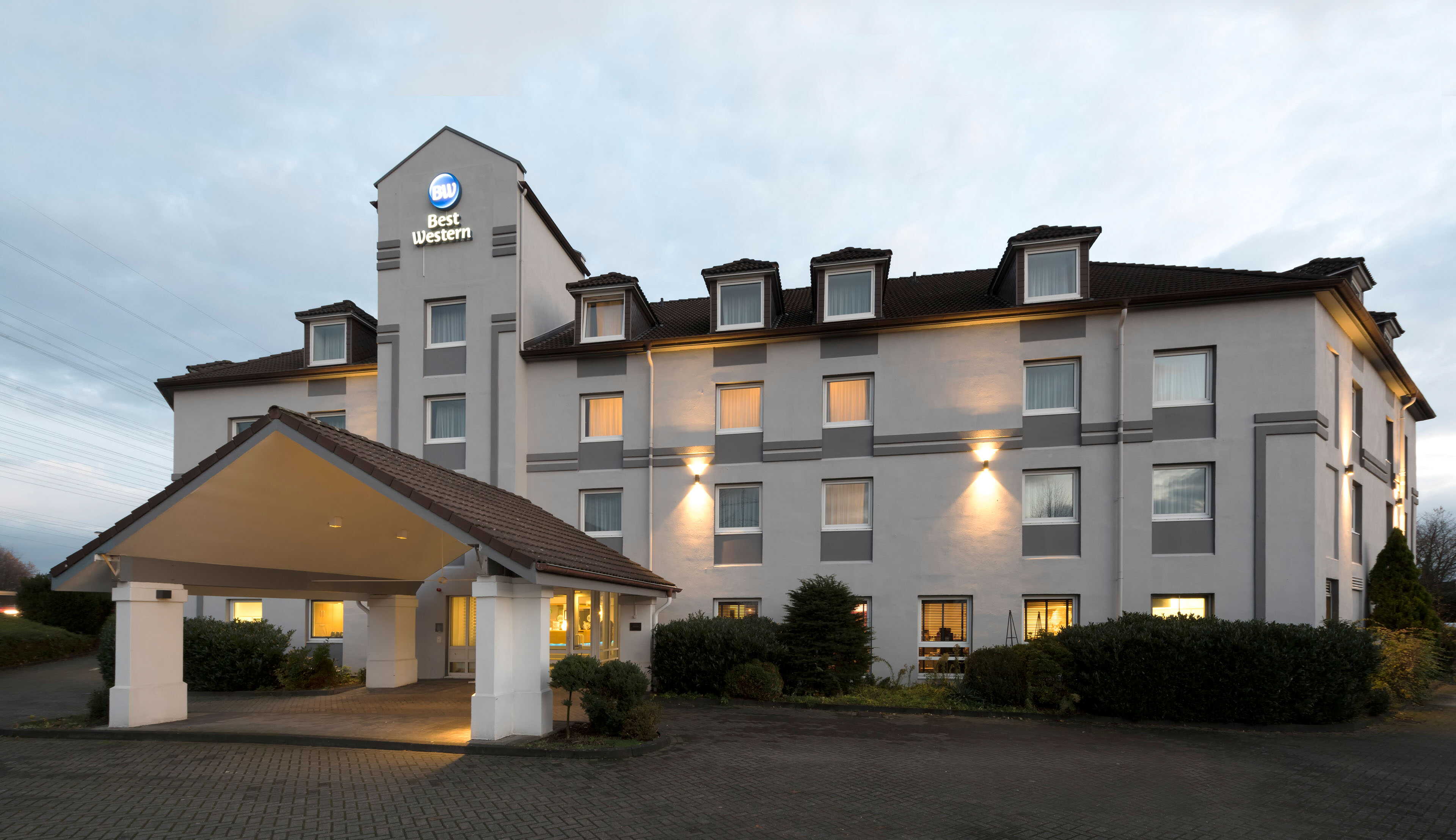 Best Western hotel cologne airport roisdorf: inviting exterior at dusk, ideally located for business and leisure travelers. Comfort and quality await you.