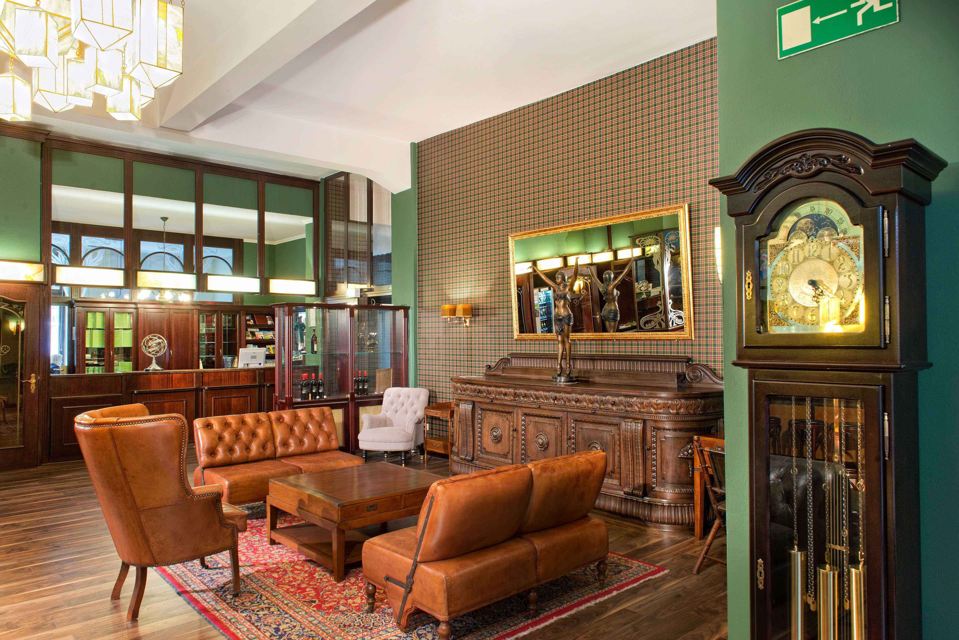 The elegant hotel lobby features leather seating, an ornate reception desk, and a vintage grandfather clock.