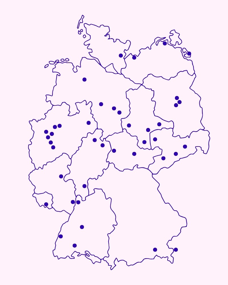 Eine Karte von Deutschland zeigt mehrere markierte Standorte durch violette Punkte auf einem hellen Hintergrund.
