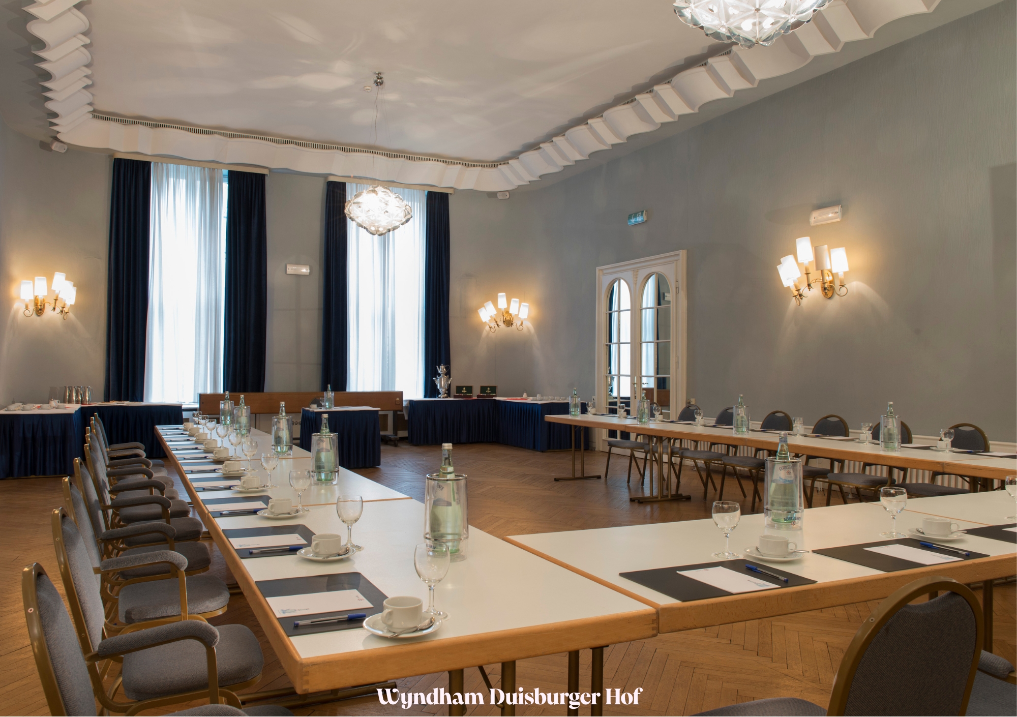 Ein eleganter Konferenzraum mit gedecktem Tisch, bereit für ein Meeting im Wyndham Duisburger Hof.